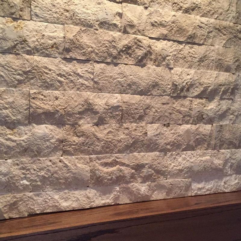 Stone fireplace wall with wooden mantel and glass insert