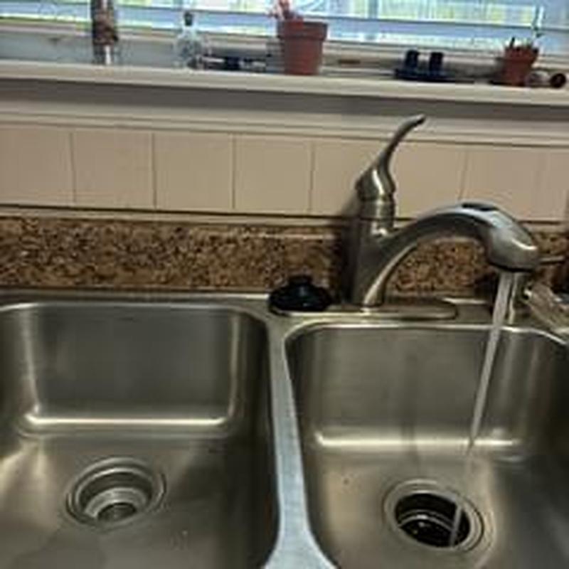 Kitchen sink drain with running faucet in countertop