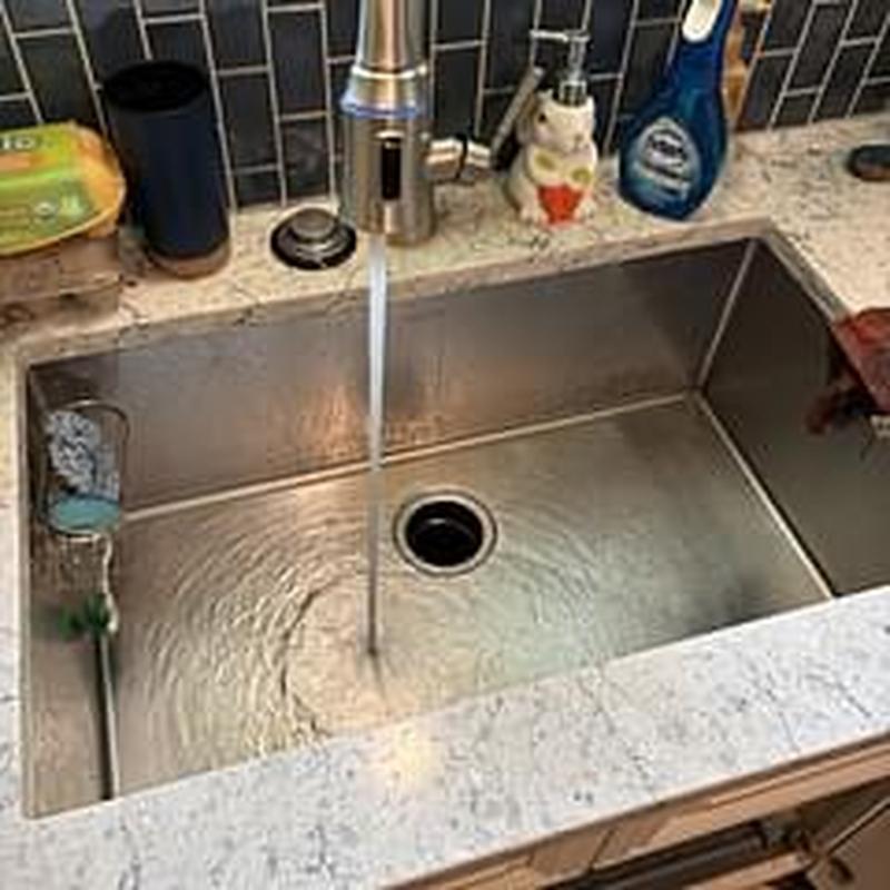 Kitchen sink drain with flowing water and faucet