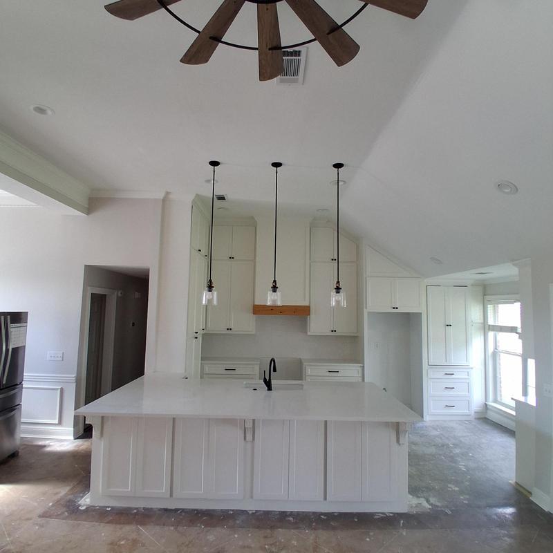 Kitchen island with white cabinetry and pendant lighting