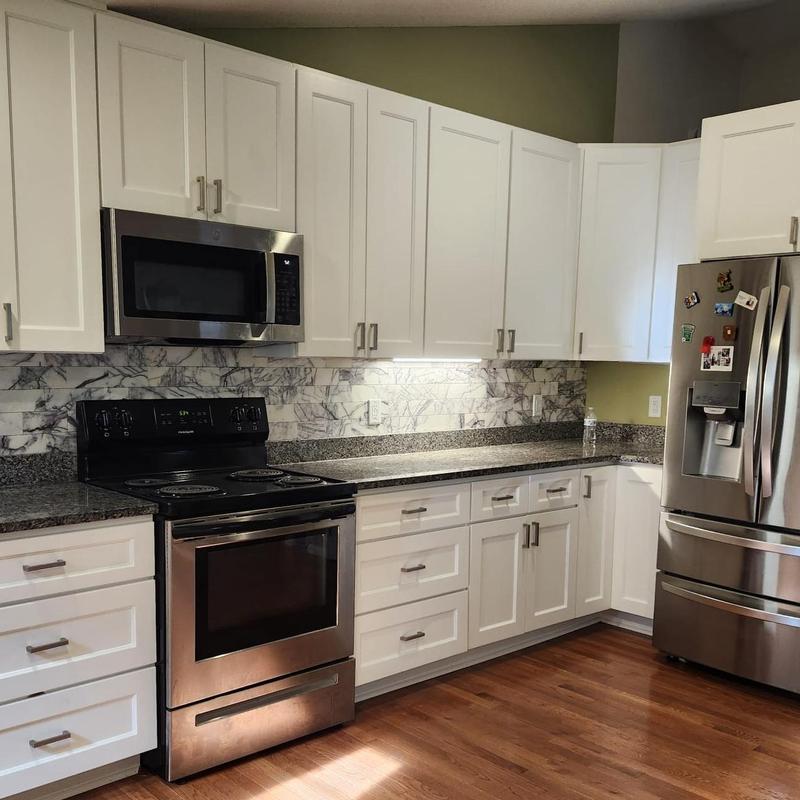 White kitchen cabinets with granite countertops and backsplash