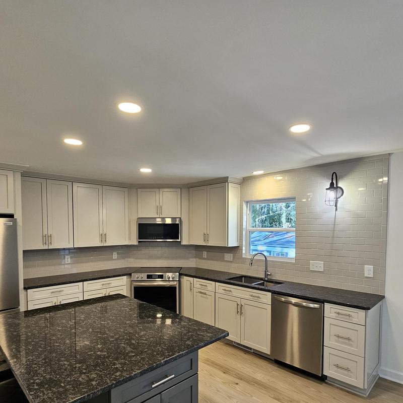Kitchen tile backsplash with white cabinets and granite counters