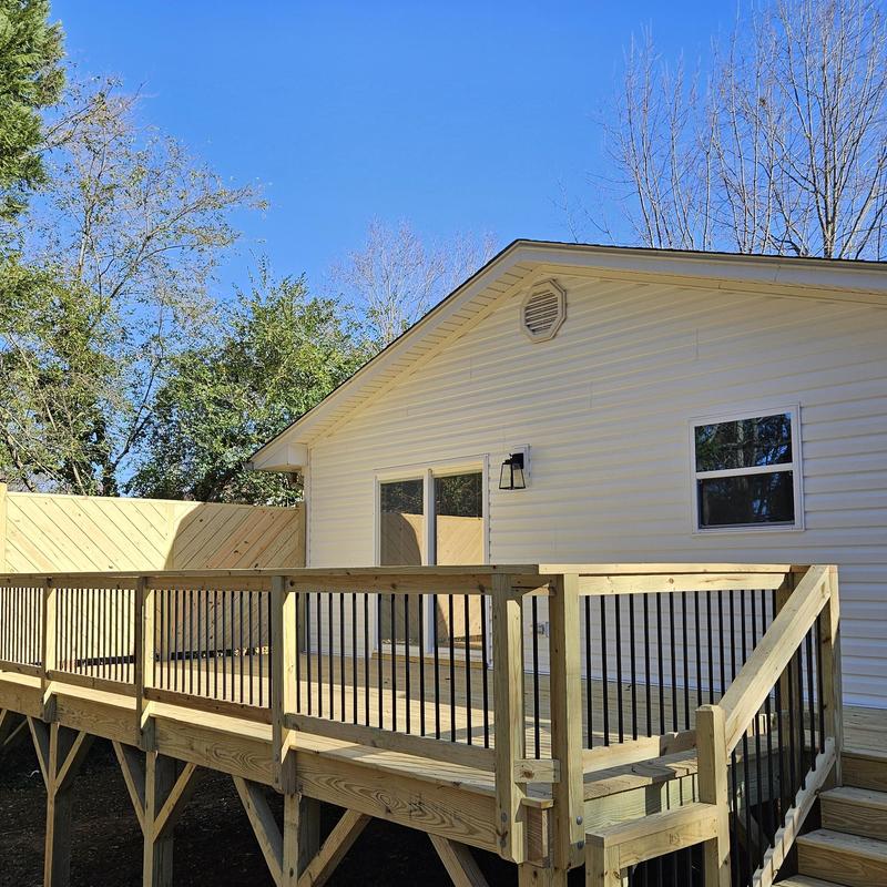 Wooden deck with black metal railing and steps
