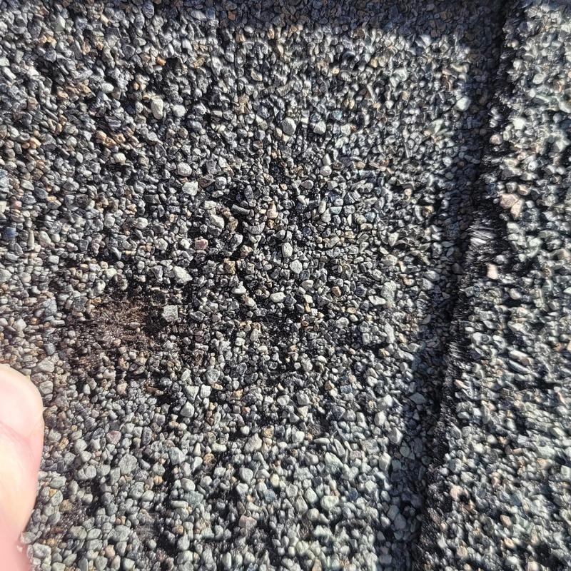 Asphalt shingle roofing damage from hail impact close-up