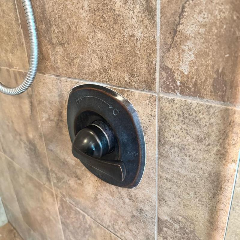 Delta shower valve handle on tiled wall