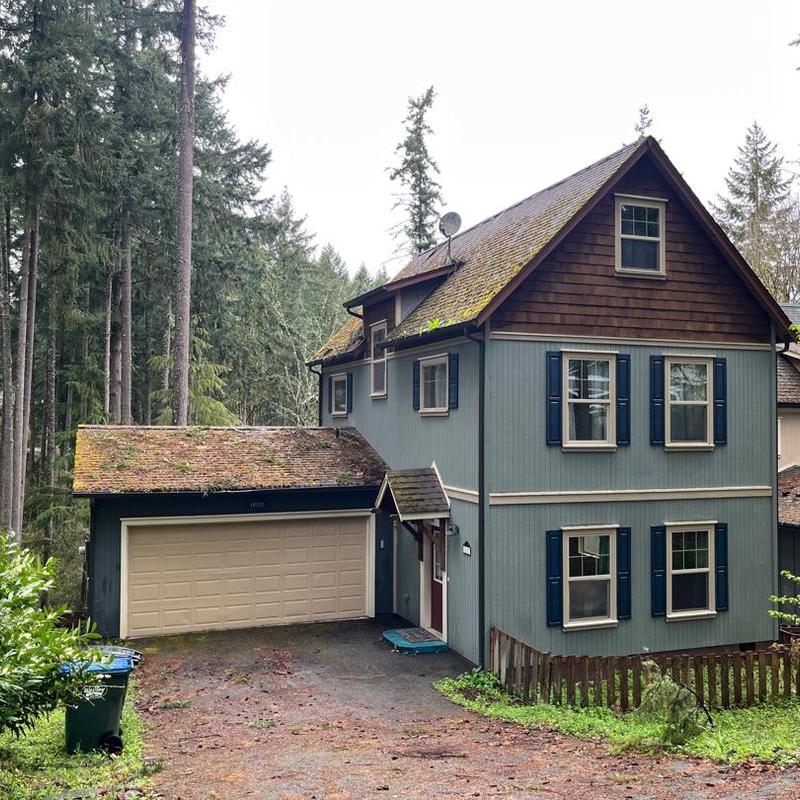 Roof with moss buildup on residential house in forested area