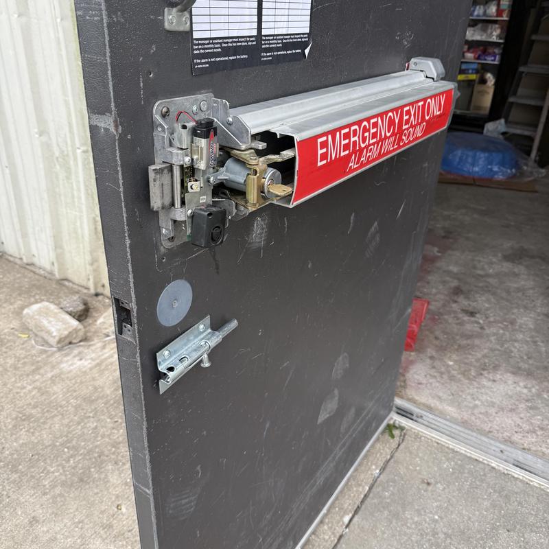 Exit device and key cylinder on emergency exit door
