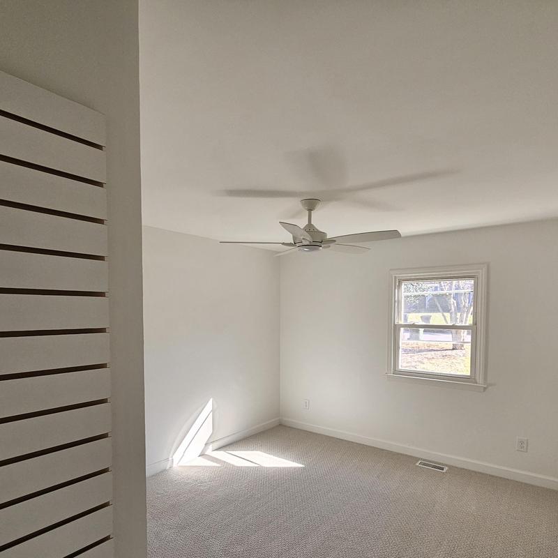 Ceiling fan and window installation in empty bedroom
