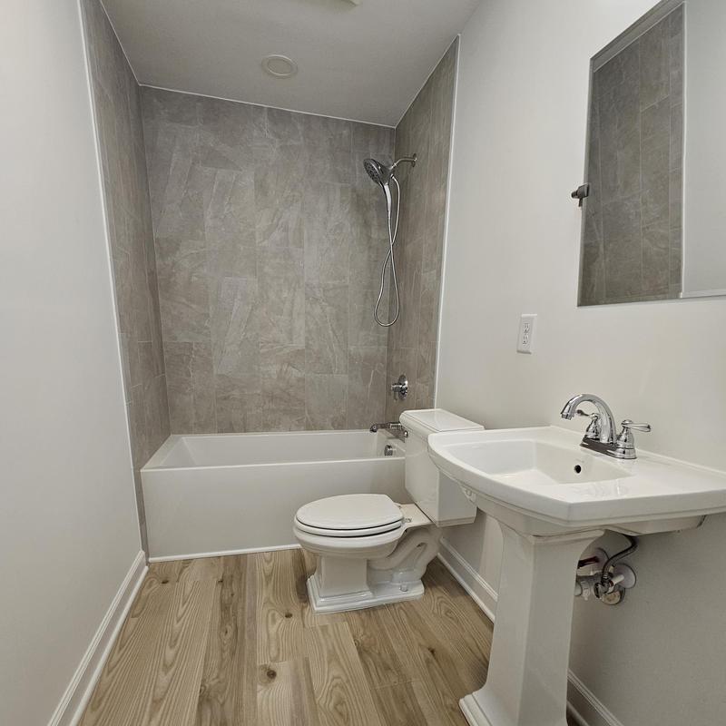 Bathroom shower and tub with tile surround and pedestal sink