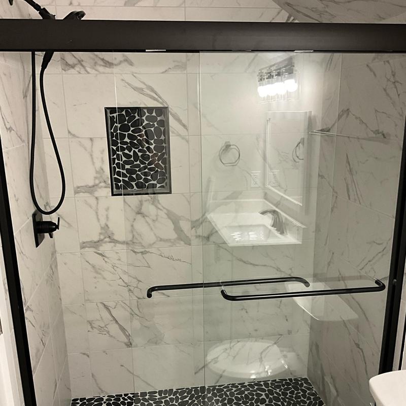 Marble tile shower with black frame sliding door