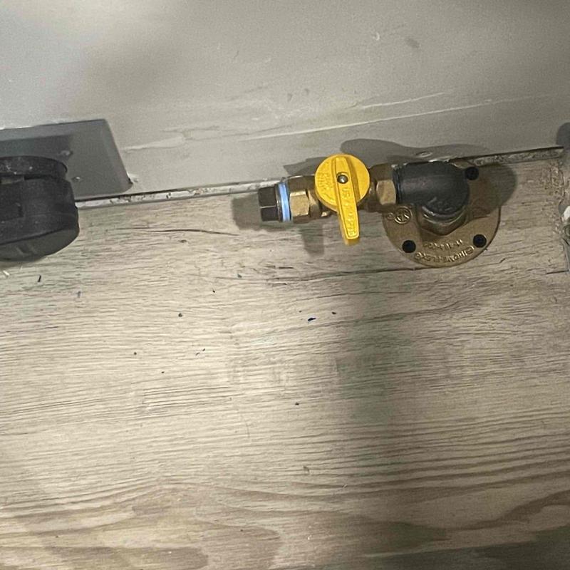 Gas line shutoff valve installed on wood floor