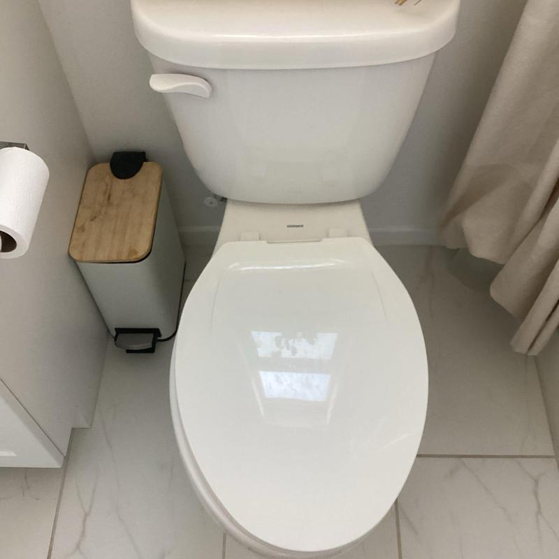 Toilet with closed lid in bathroom corner