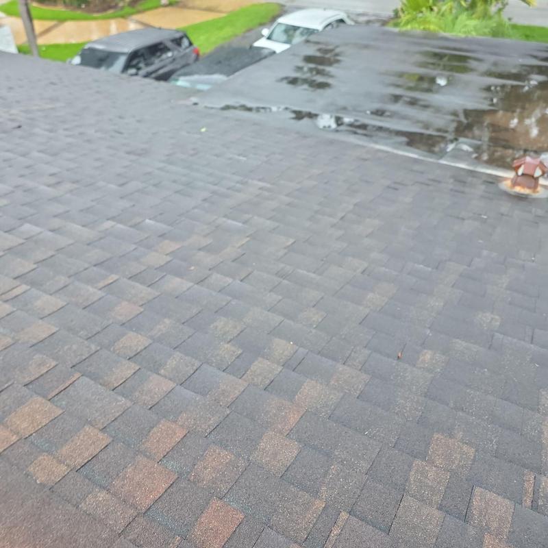 Asphalt shingle roof with adjacent flat roof section
