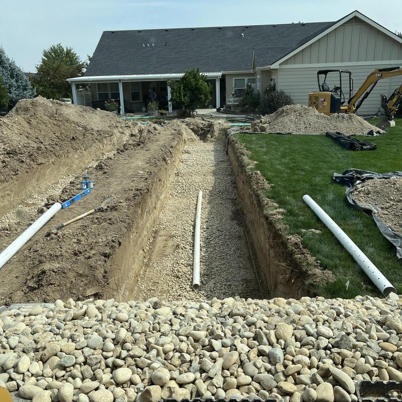 Drain field installation with gravel base and PVC piping