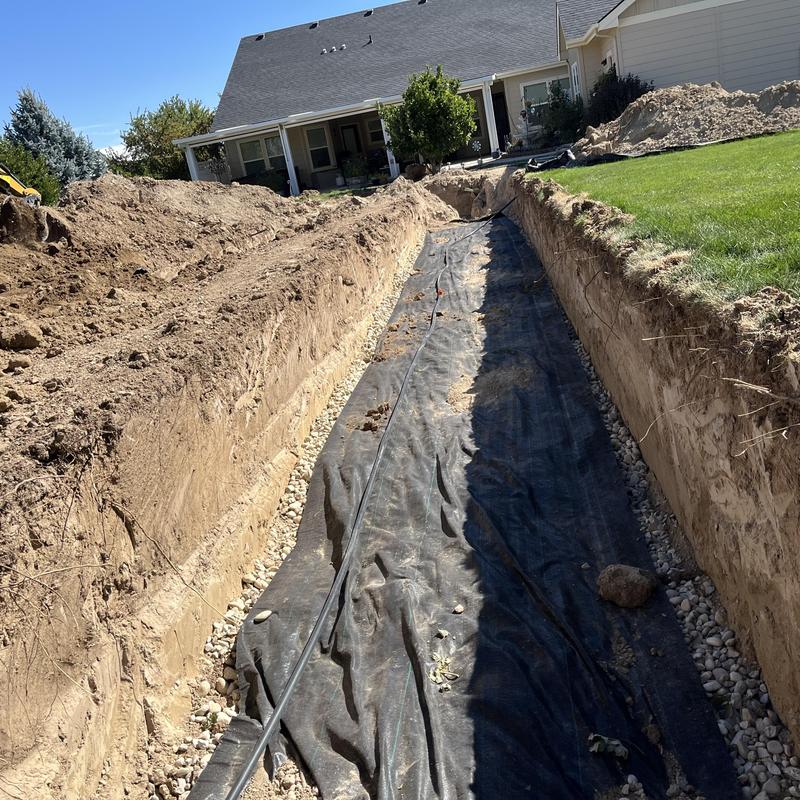 Drain field excavation with rock and fabric liner installation