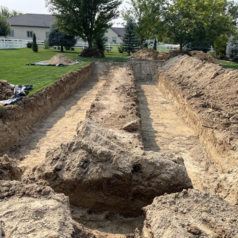 Septic drain field excavation with soil piles