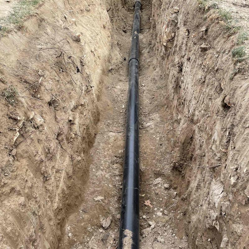 Main sewer line installation in dirt trench