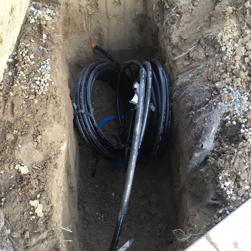 Black poly water line coil in dug trench