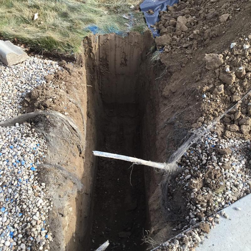 Water meter excavation hole with exposed cable lines