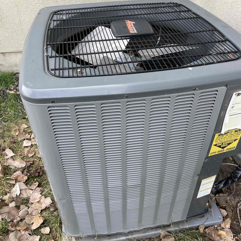 Air conditioner condenser unit outdoors with fan guard