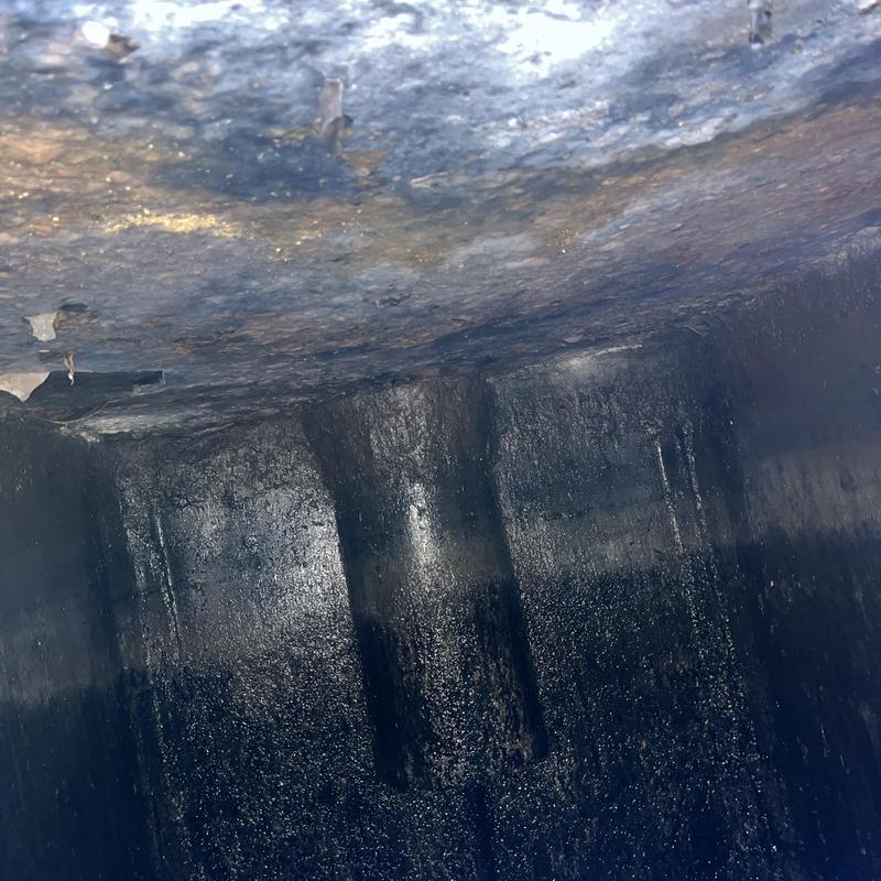 Septic tank interior showing thick crust layer buildup