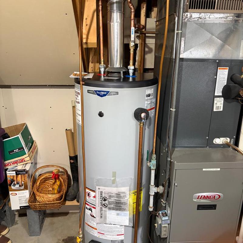 Water heater with copper piping near furnace in basement