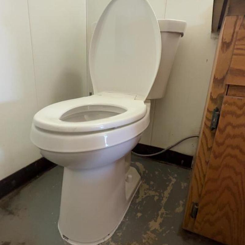 Toilet with open lid in commercial bathroom