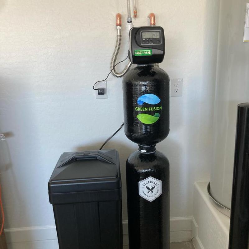Green Fusion water softener system installed in garage