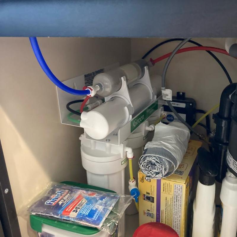 Green 5-stage RO water filtration system installed under sink