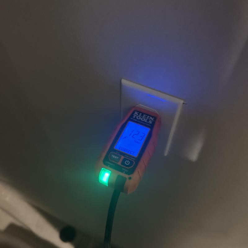Electrical outlet voltage tester showing 123 volts