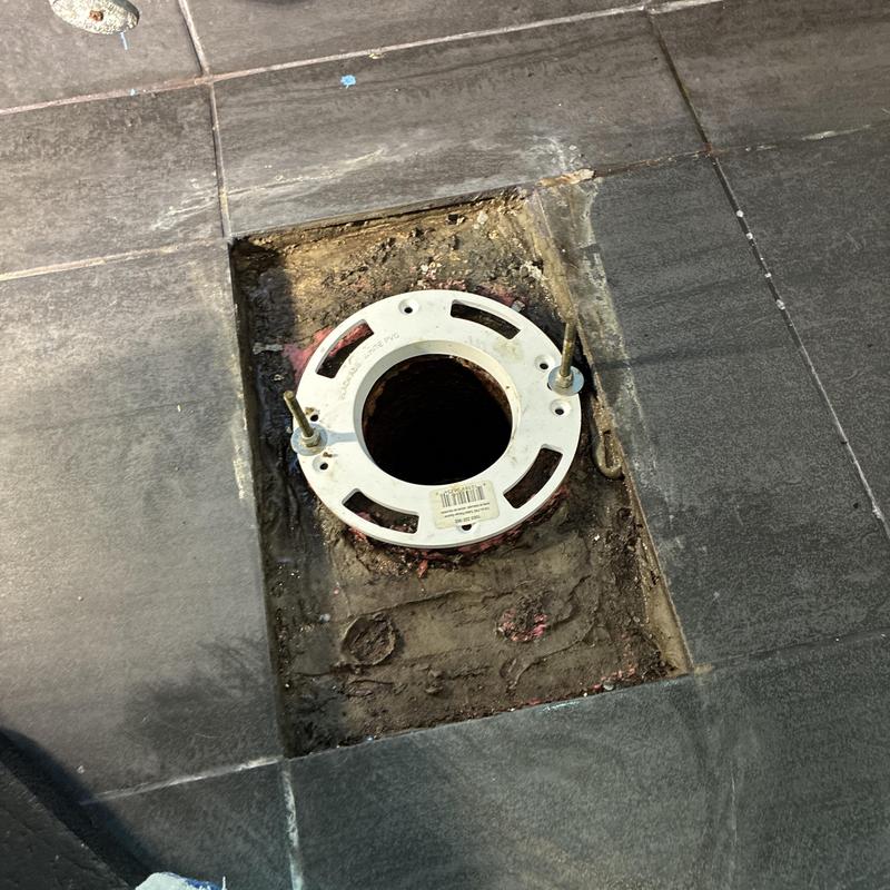 Toilet flange installation on tiled floor in bathroom
