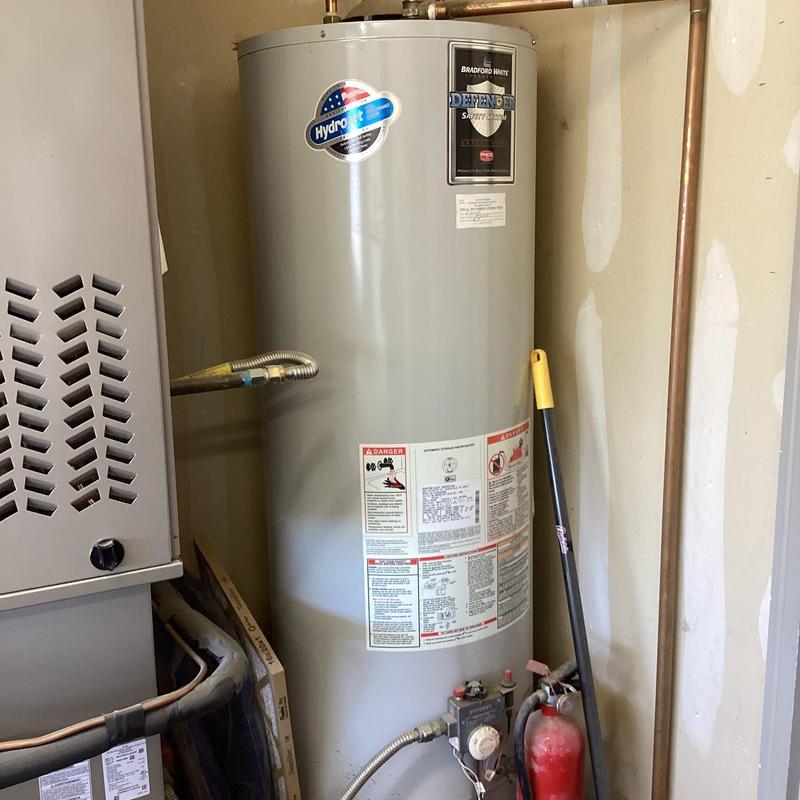Water heater with connected gas and water lines in utility room