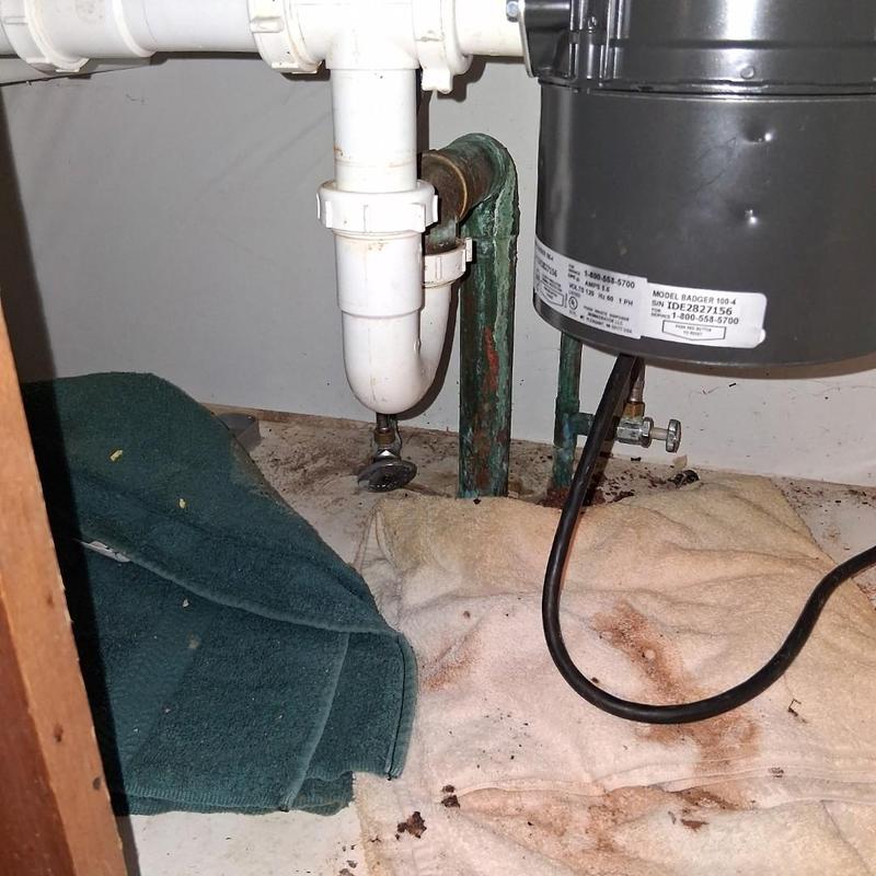 Kitchen drain pipes with garbage disposal and towels