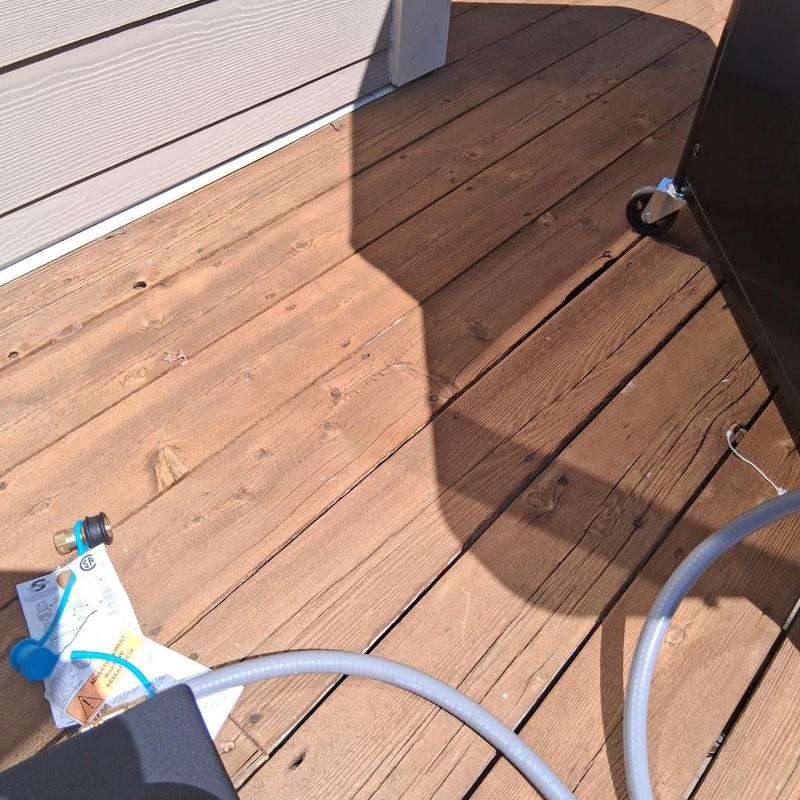 Natural gas grill hose connection on wooden deck