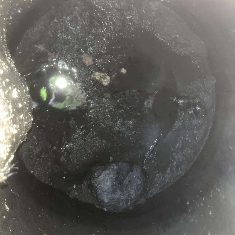 Septic tank interior with sludge and debris visible