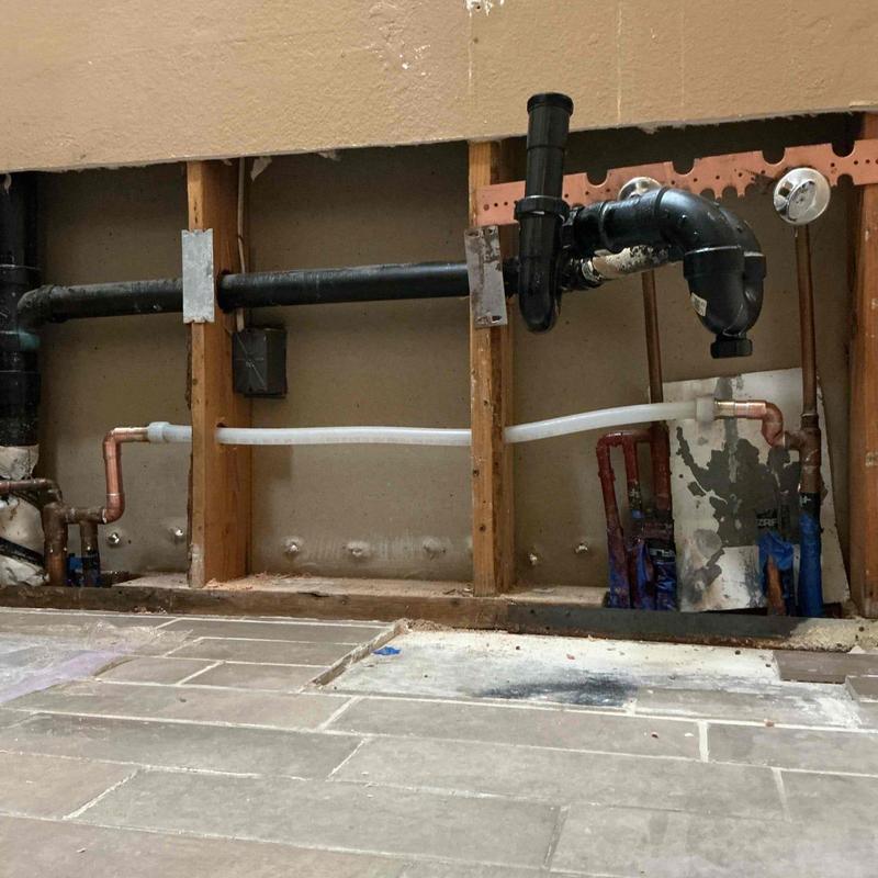 PEX piping connected to copper manifold behind wall