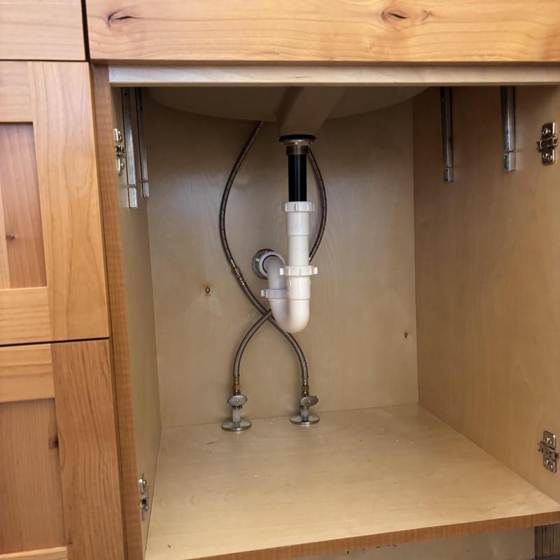 Sink drain and water supply lines inside cabinet