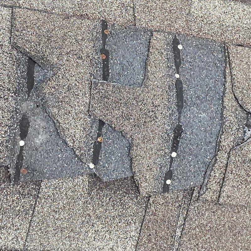 Asphalt roofing shingles damaged by wind and hail