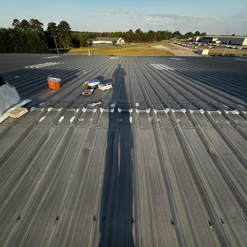 Galvanized metal roof ridge vent installation in progress