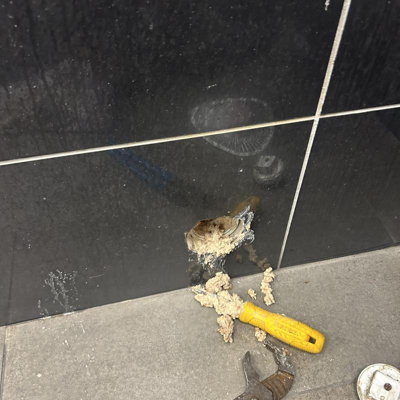Bathroom drain clog with removed debris and tools nearby