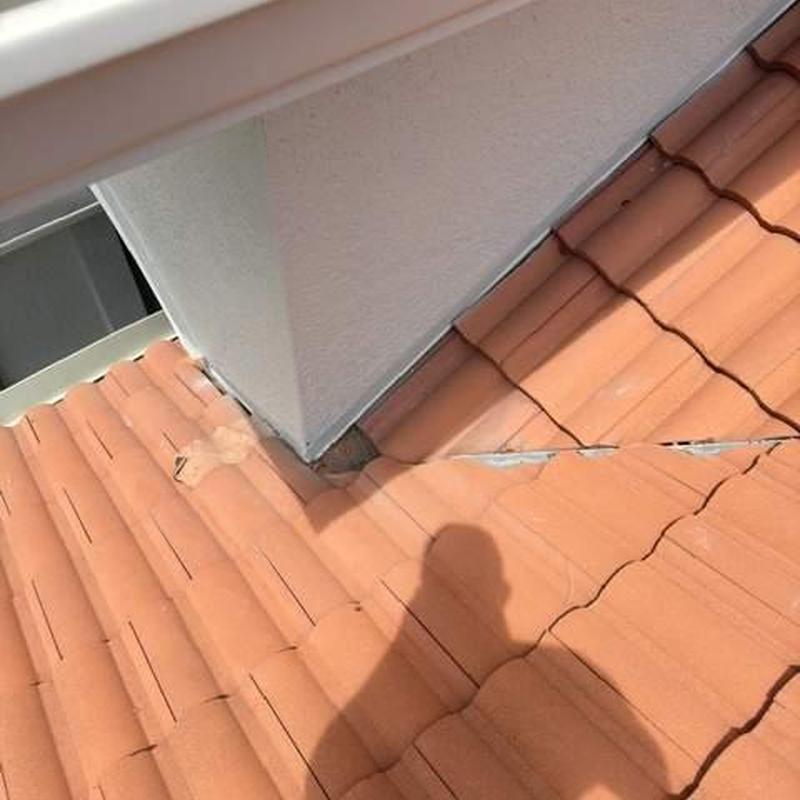 Concrete tile roof with tile removal near chimney base
