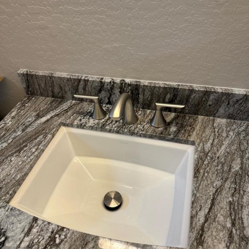 Widespread bathroom sink faucet with granite countertop
