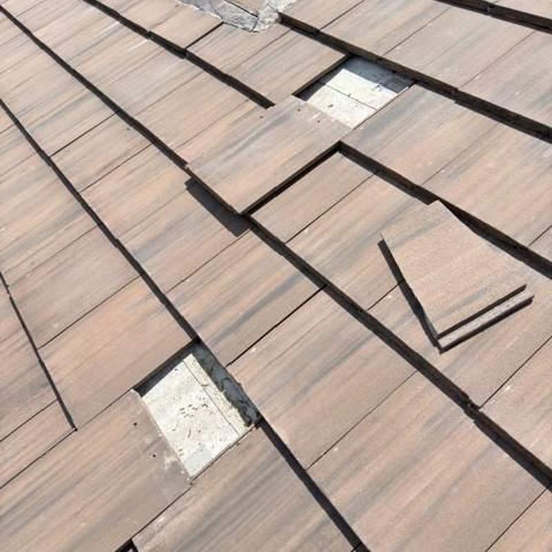 Concrete tile roof with missing and displaced tiles
