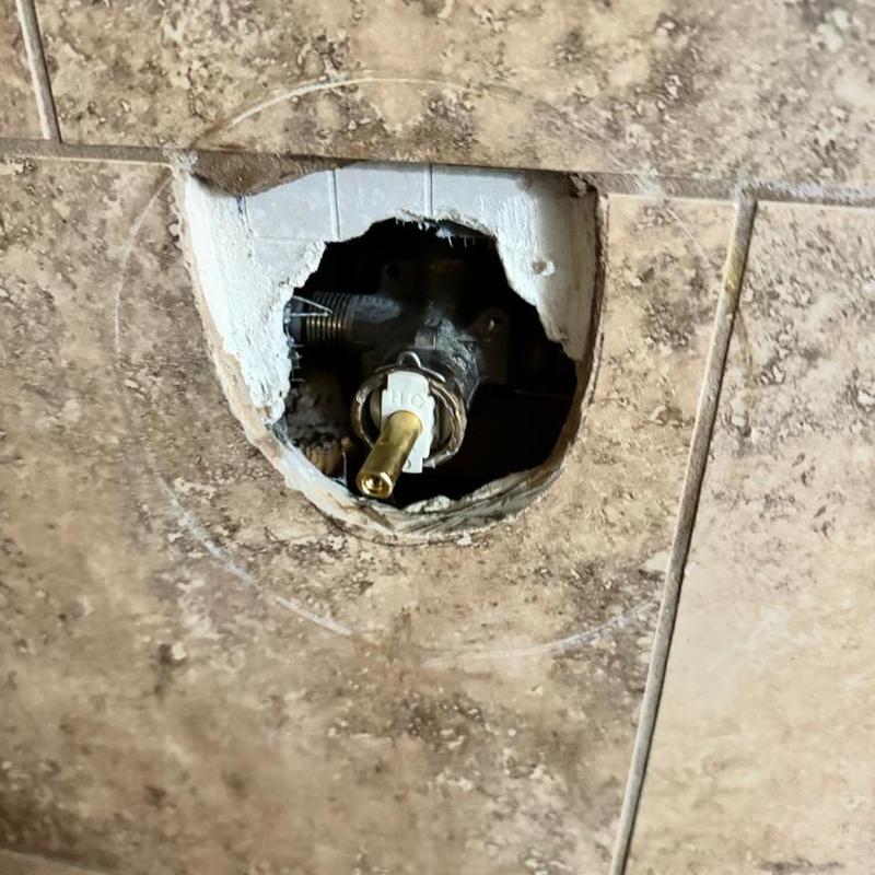 Shower valve cartridge removed from tiled wall hole