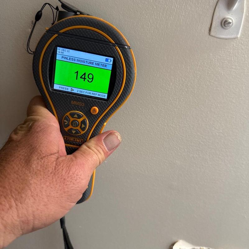 Moisture meter testing drywall for water damage