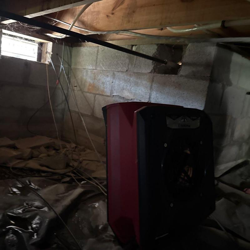 Crawl space dehumidifier operating near foundation wall