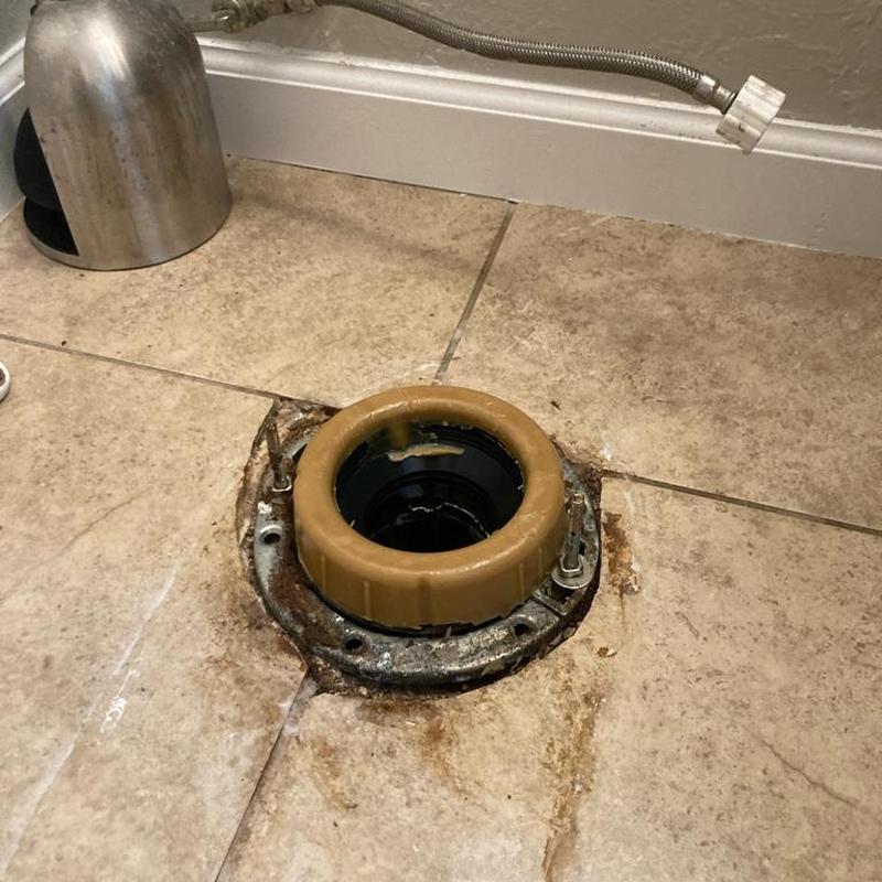 Toilet flange and wax ring on bathroom floor