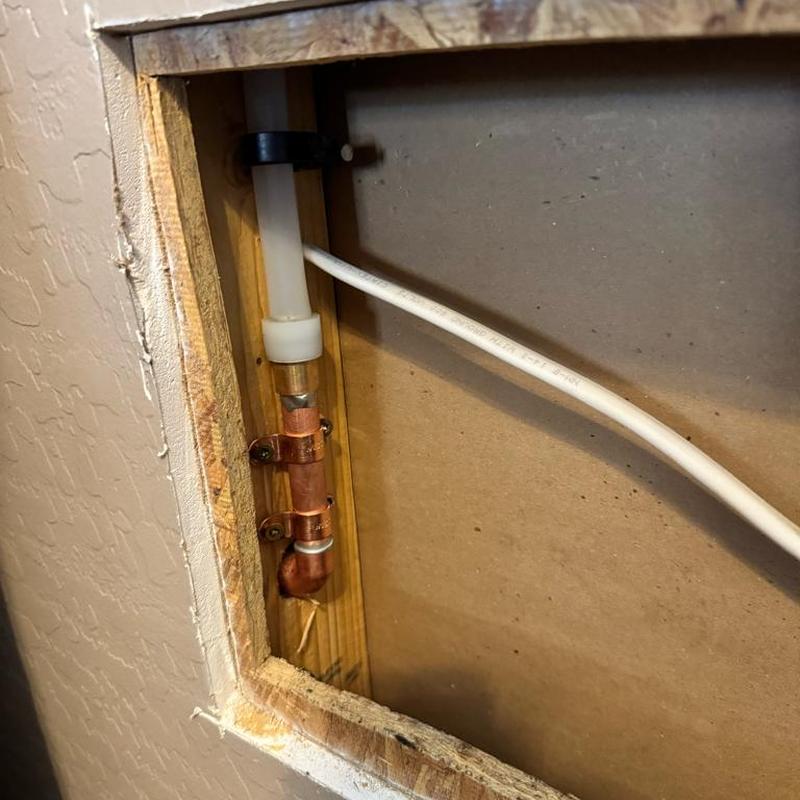 Copper water line secured inside wall cavity