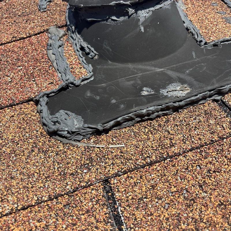 Roof flashing with hail damage and sealant buildup