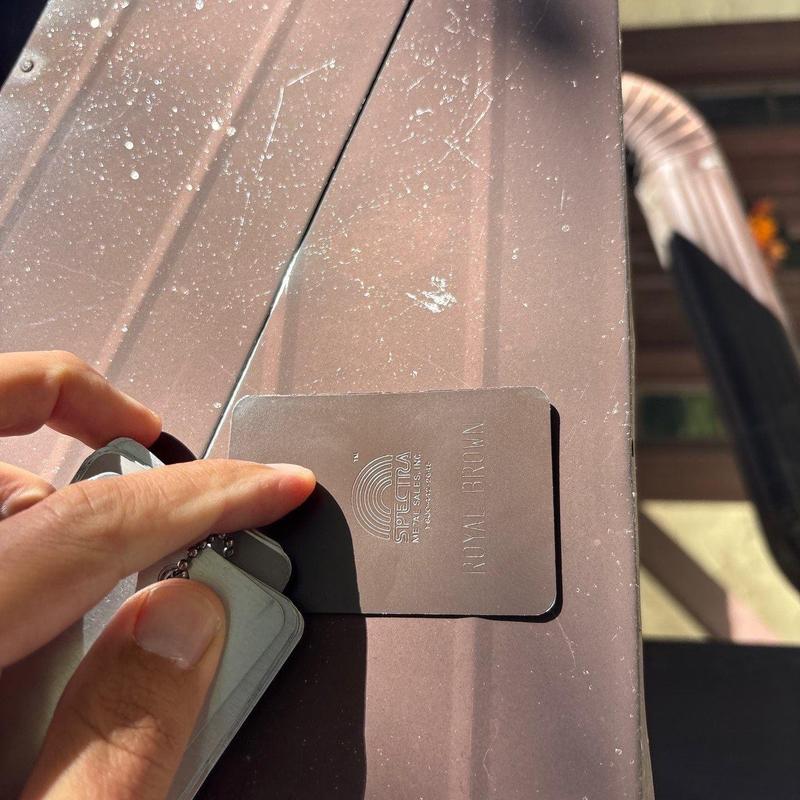 Metal roof panel with hail impact damage and color sample